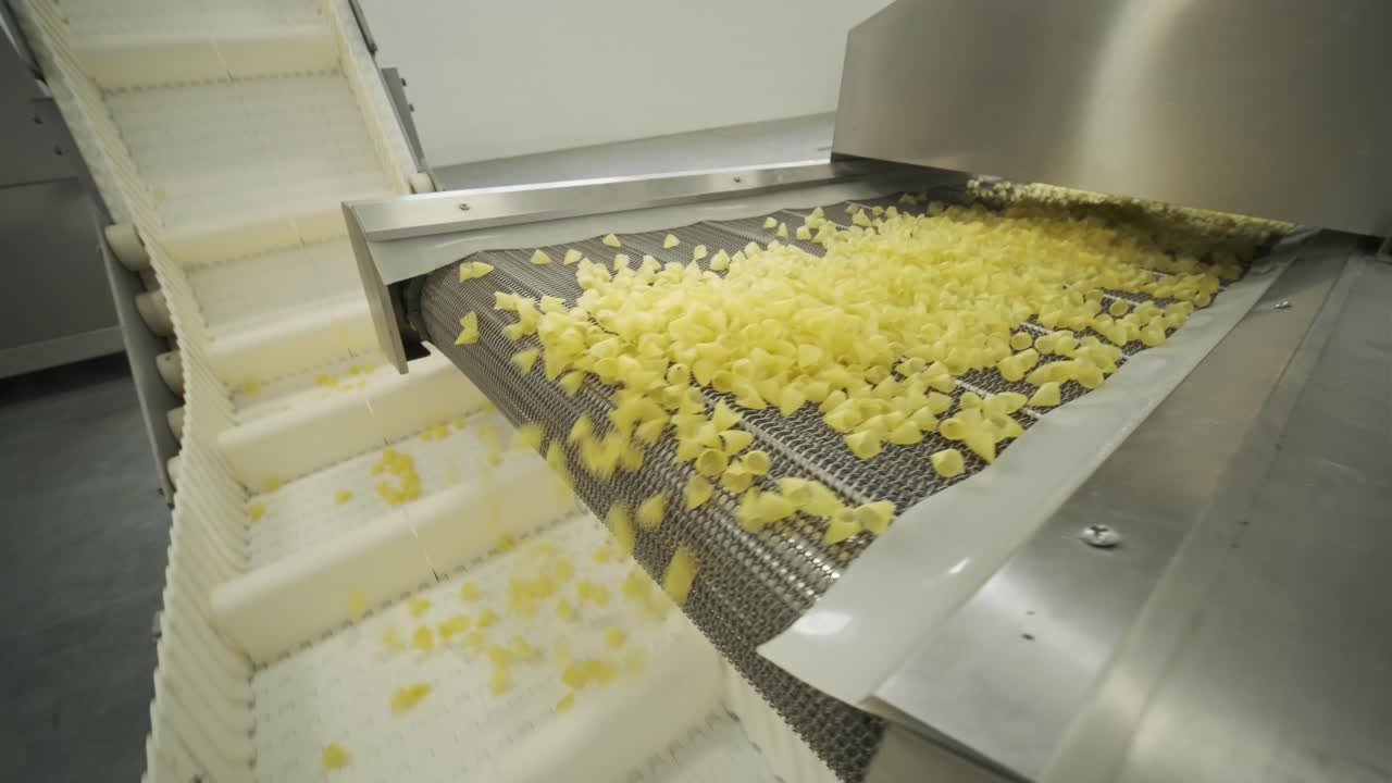 Jalur produksi pabrik memindahkan camilan kentang. Jalur produksi pabrik pasta, produksi dan penyortiran pasta.
