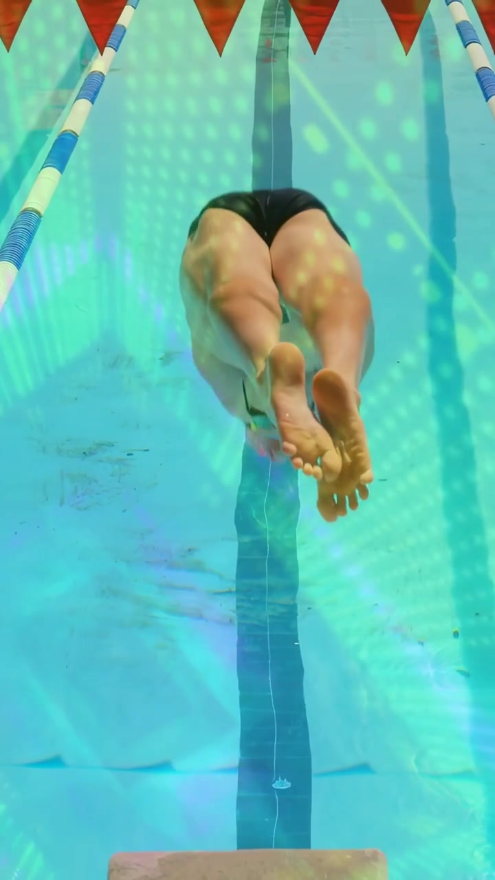 Video verticale: Nuotatore che si spinge dal blocco di partenza, con un arco animato che traccia il tuffo per l'allenamento.