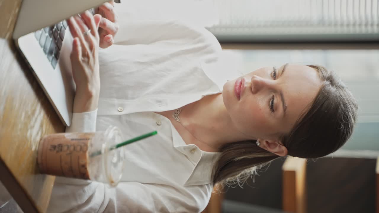 mujer trabajando en una computadora portátil en un café