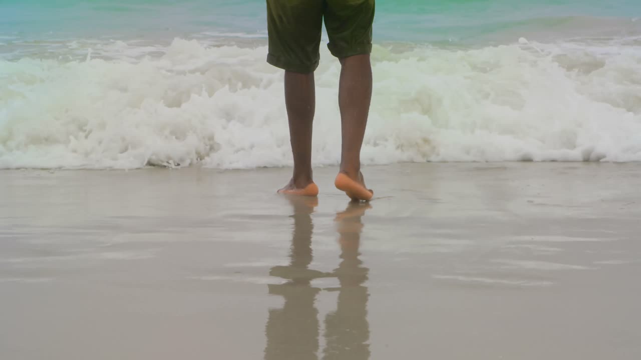 Parte inferiore di uomo in piedi sulla spiaggia 4k