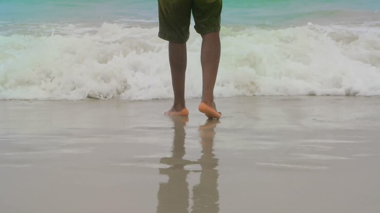 Parte inferiore di uomo in piedi sulla spiaggia 4k