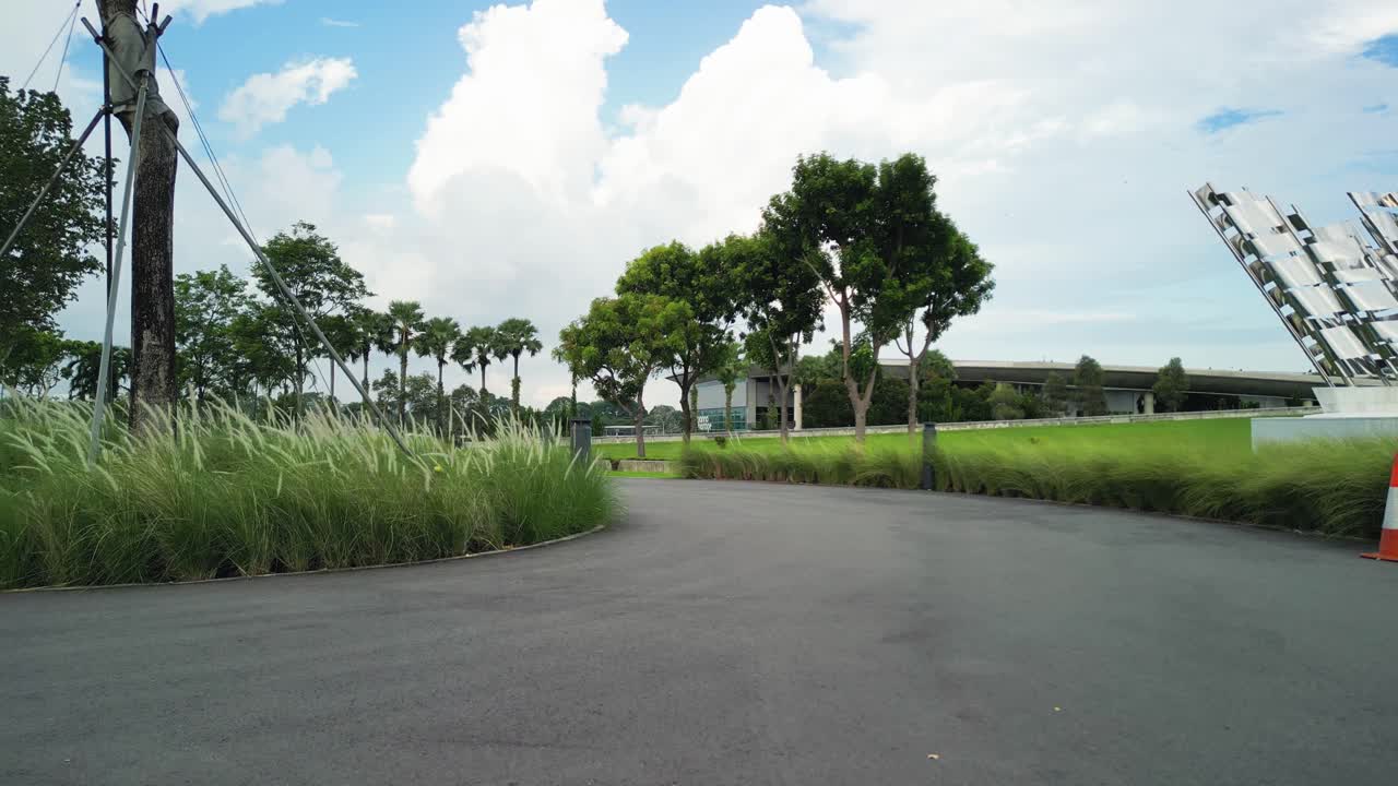 Take off drone aerial of Marina Barrage, part of Singapore's sustainable development, park for recreation with tree lines and grass