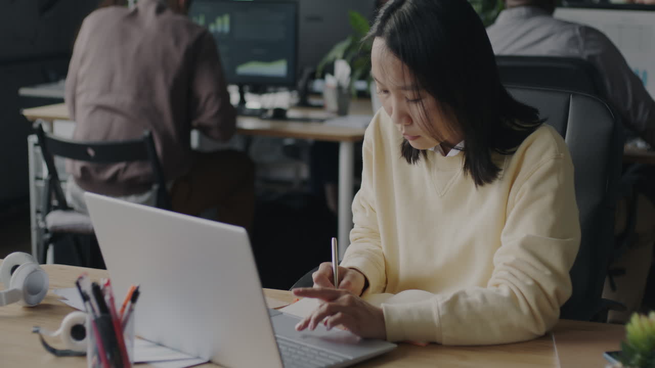 사무실에서 노트북으로 일하는 여자