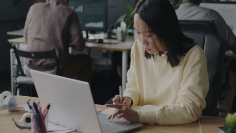 woman working on a laptop in an office