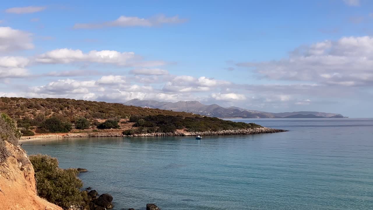 Calm bay with boat and coastal landscape at Voulisma Beach, Crete, Greece