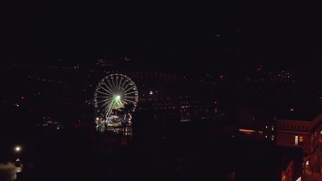 Zakopane-ferris-wheel-at-night,-Poland.-Aerial-forward