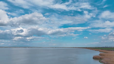 Drohnen-Hyperlapse-über-Einem-See-Mit-Vorbeiziehenden-Weißen-Wolken