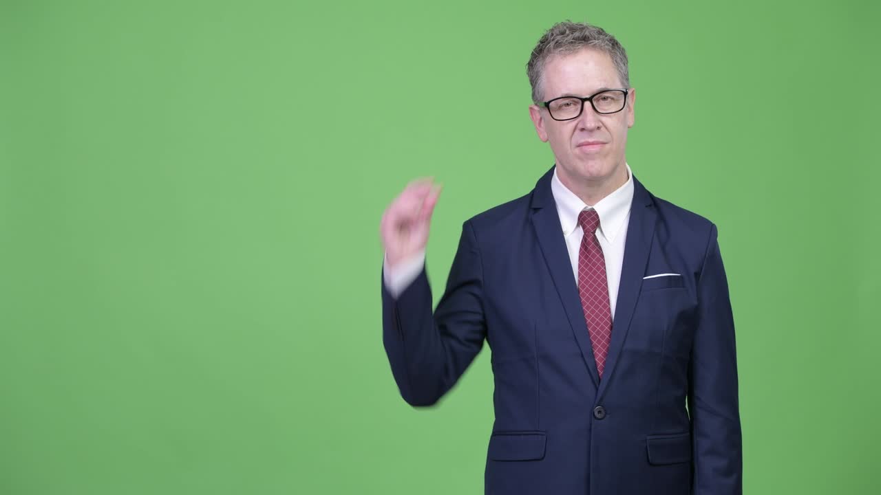 Happy mature businessman with eyeglasses snapping fingers and showing something