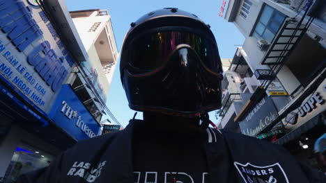 person in motorcycle helmet on city street