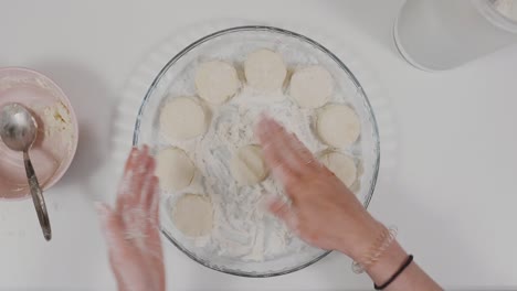 cocinar rollos de queso cottage, pasteles de queso. cocinar masa, cocinar masa. una mujer está cocinando en casa, en tiempo real. vista desde arriba. panqueques de queso casero