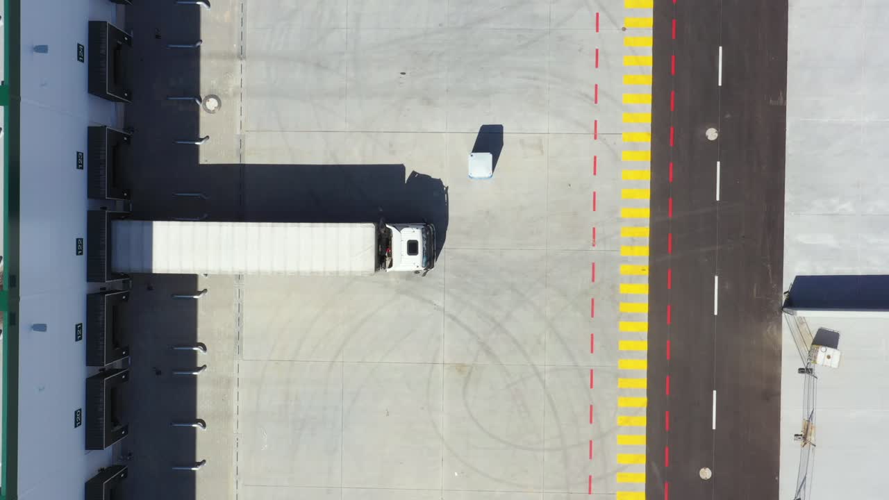 toma aérea del muelle de carga del almacén industrial donde muchos camiones con semirremolques cargan mercancías