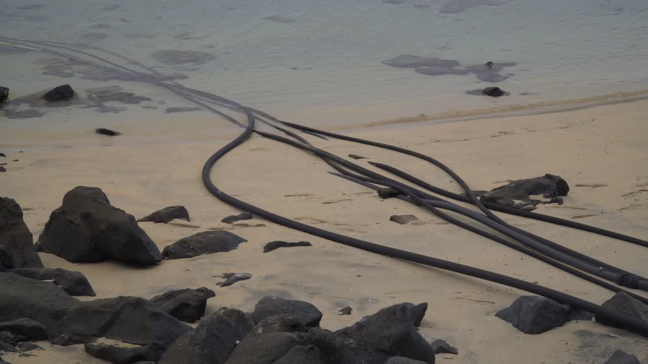 바다의 염수로 들어가는 긴 검은색 파이프, 담수화 시스템, 피지