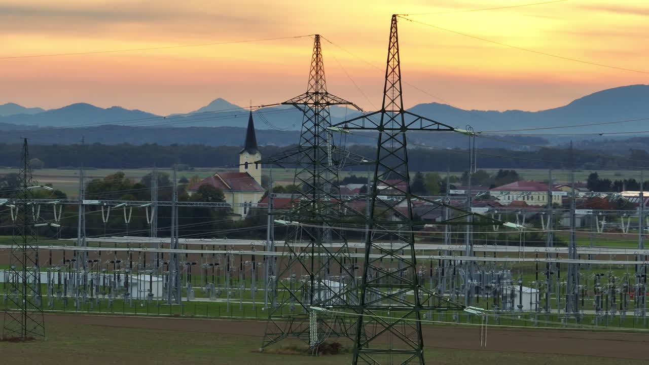 夕暮れの中、変圧器と送電線がある高圧変電所の空撮