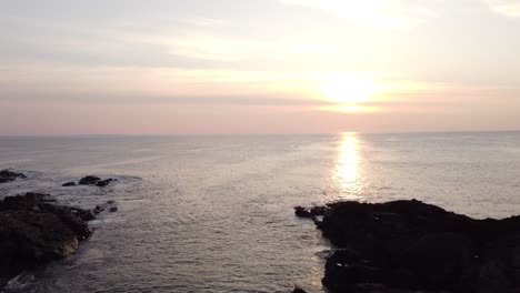 aerial-of-scenic-coastline-cliff-during-sunset-on-ocean-calm-peaceful-nature-footage