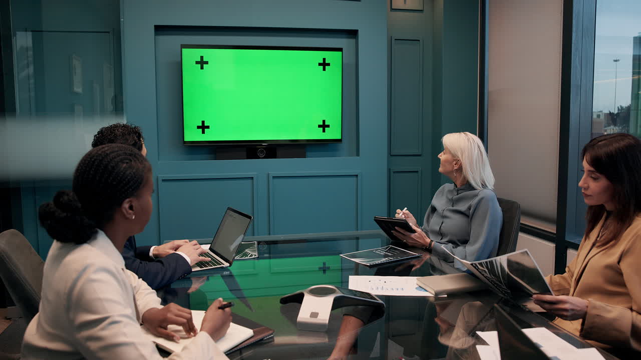 Business meeting with green screen display