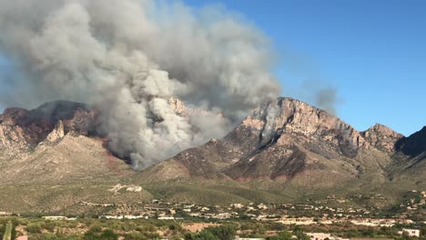 Airplane-Flying-Low-Above-Burning-Hills,-Dropping-Retardant-on-Wildfire