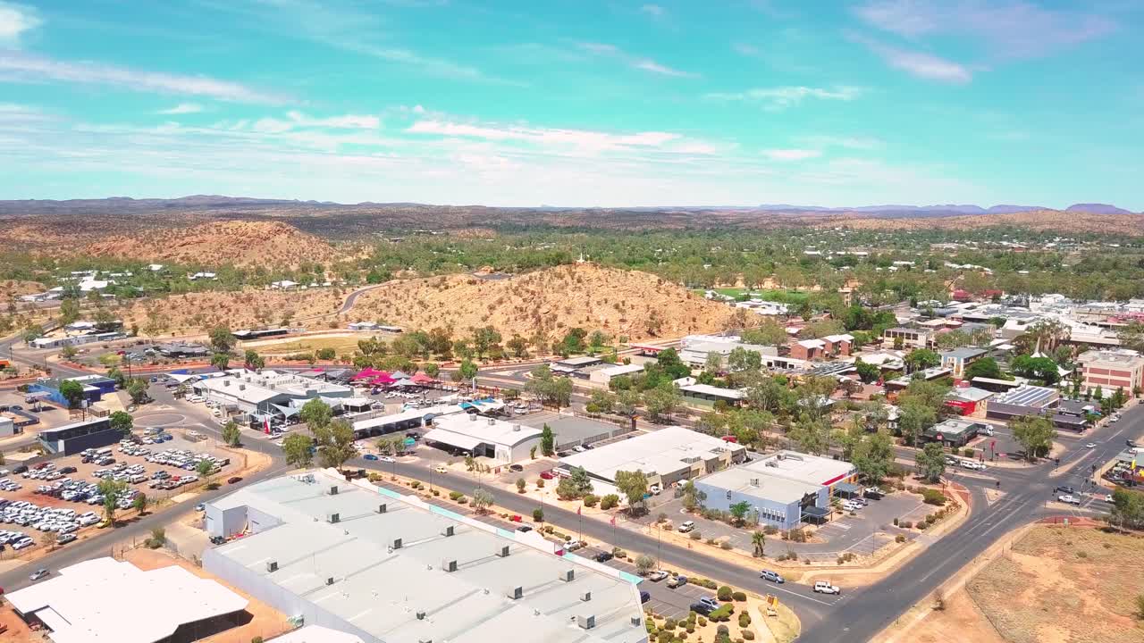 Alice Springs - Australia. Cinematic aerial flyover of outback city with red sad outback desert beyond. Filmed on DJI Mavic Pro