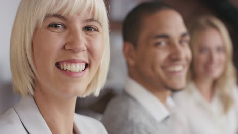 Porträt-Einer-Selbstbewussten-Jungen-Geschäftsfrau-Am-Sitzungstisch-In-Trendigen,-Modernen-Gemeinschaftsbüroräumen,-Ein-Vielfältiges-Team,-Das-Sich-In-Zeitlupe-Unterhält-Und-Sich-Lächelnd-Umdreht