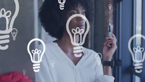 animation of lightbulb icons over african american businesswoman thinking