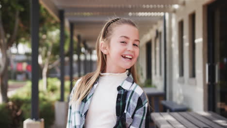 playful girl balancing pencil on upper lip outside school, having fun