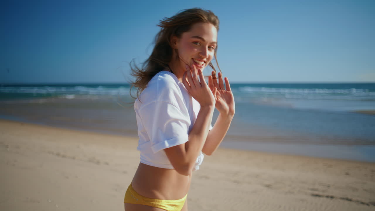 Cheerful woman walking sandy beach summer portrait. Girl strolling ocean shore