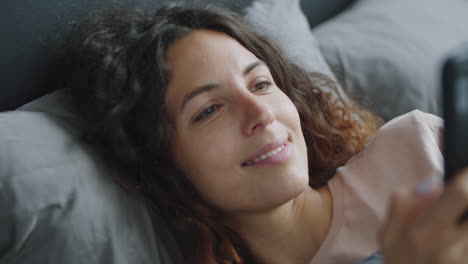 mujer usando el teléfono en la cama
