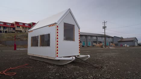 una casa de trineos para perros sentada en una playa seca.