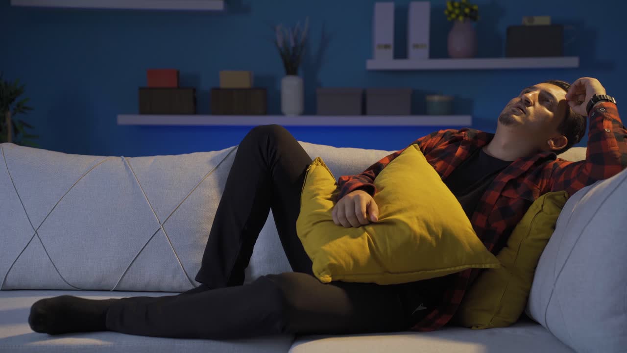 hombre deprimido acostado en el sofá.