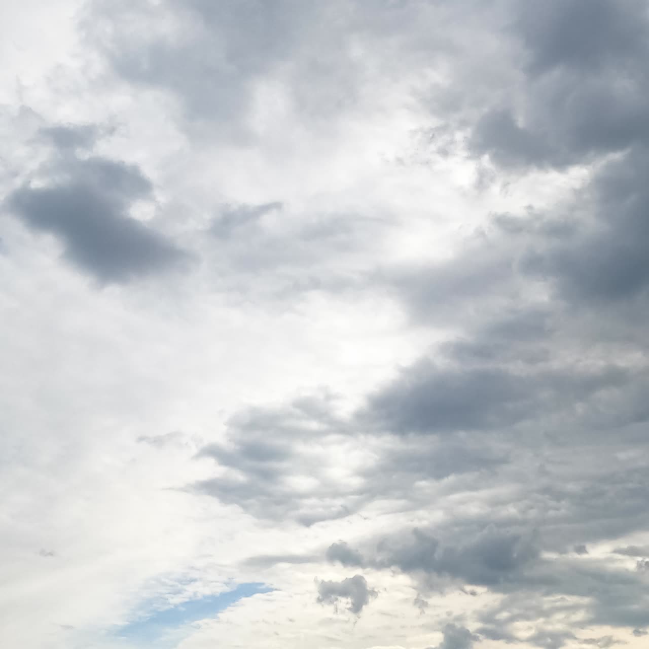 Diverse types of clouds formation in the sky. Grey cloudscape accumulating in atmosphere. Low angle timelapse
