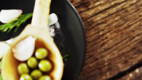 ingredients olive and garlic kept on a black plate