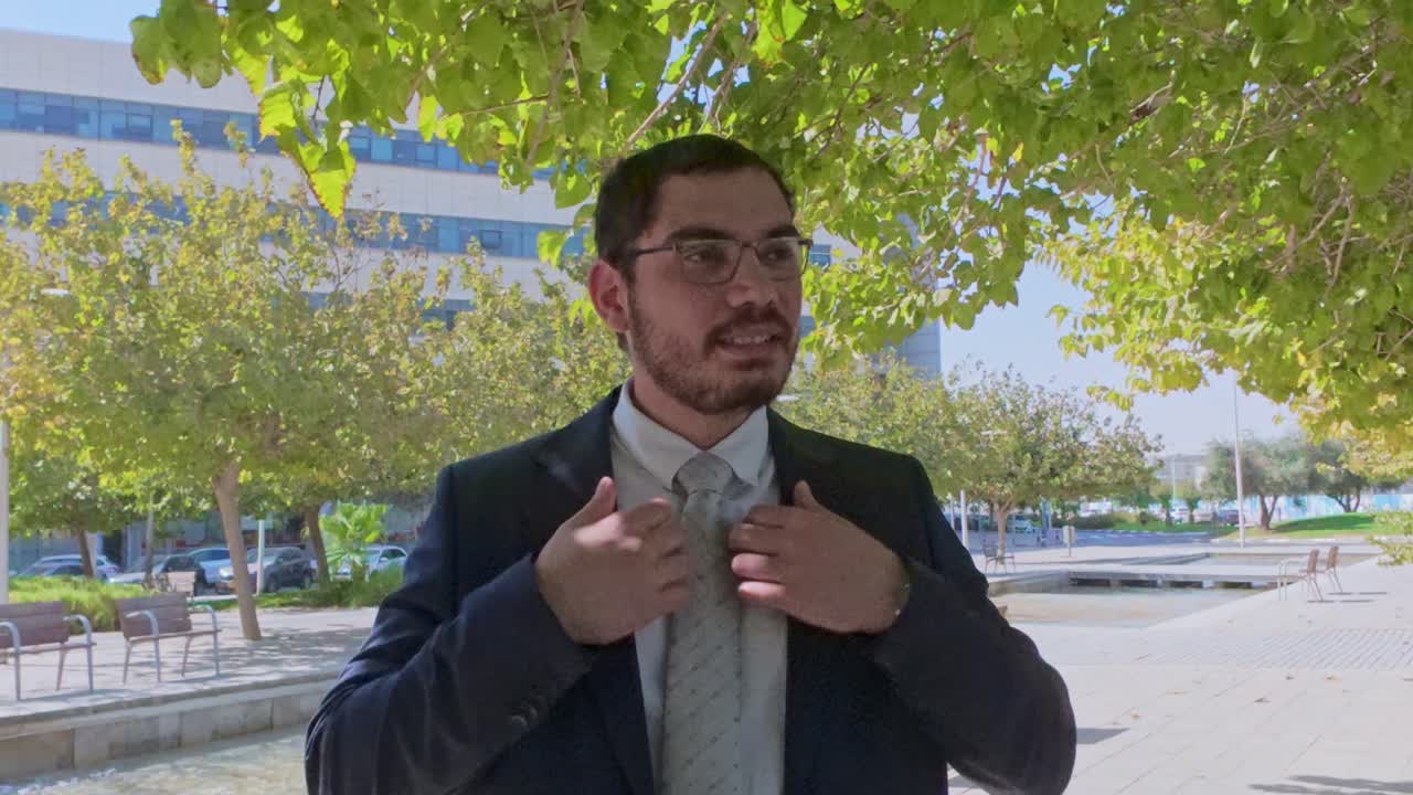 Dapper Businessman with Glasses Adjusting His Tie