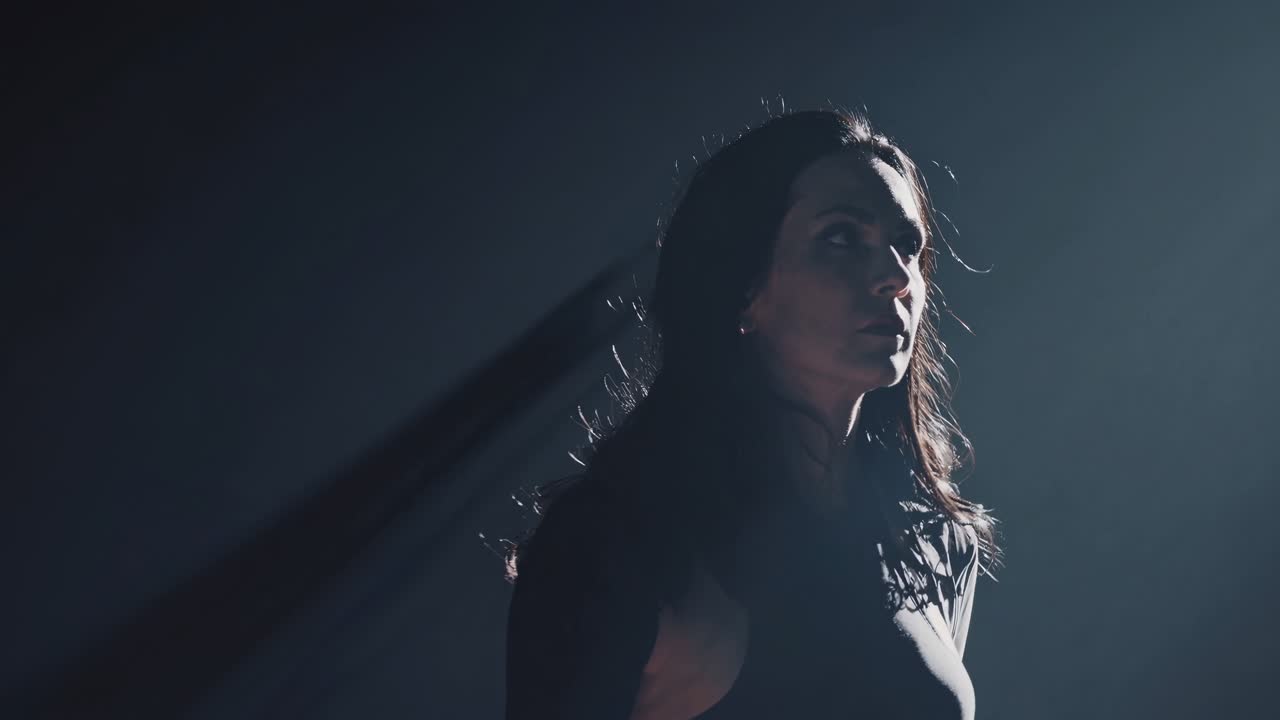 Moody video scene with a woman in a spotlight, captured from a high angle