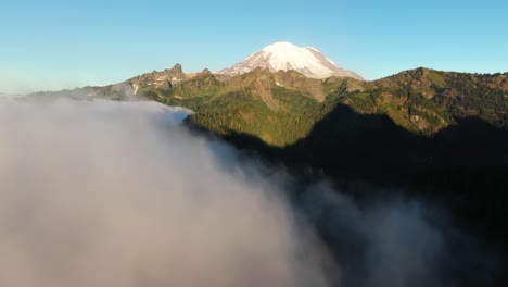 vista aérea de las nubes sobre el valle bajo el monte más lluvioso cubierto de nieve, estado de washington, ee.uu.