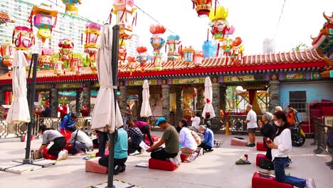 people praying with lanterns overhead in hong kong