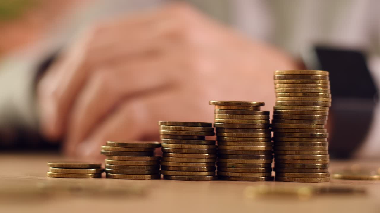 Coin stack, closeup of stacked money, male hands in background