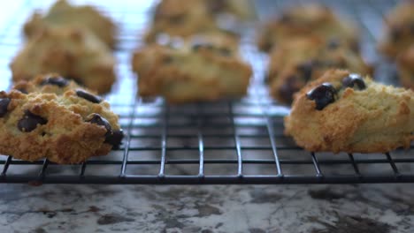 Recogiendo-A-Mano-Una-Galleta-Recién-Horneada-De-Una-Rejilla-Para-Hornear-Elevada-Bandeja-De-Rejilla-De-Refrigeración-4k-2160p-30fps-Imágenes-Ultrahd---La-Mano-De-Primer-Plano-Recoge-Una-Acogedora-Galleta-Casera-En-Casa-3840x2160-Uhd-Video