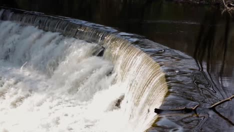 water running down stone stepped waterfall surrounded by trees and greenery-1