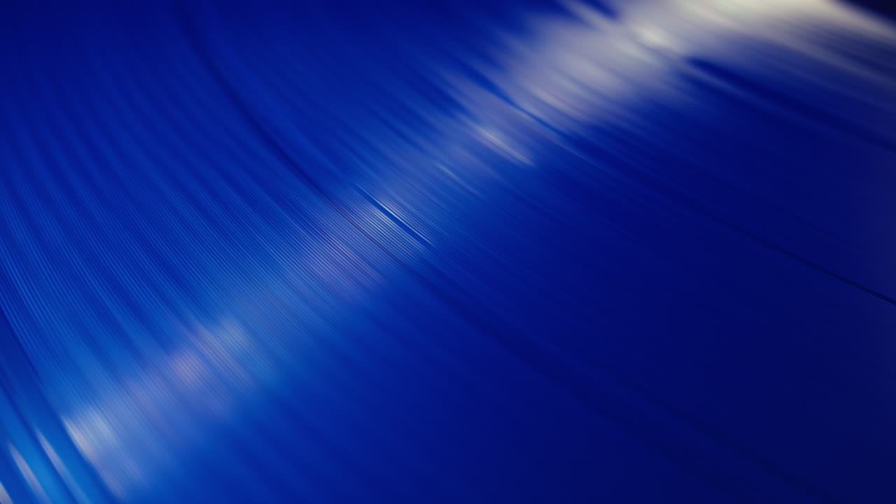 Primo piano di un disco in vinile blu che gira con i suoi solchi