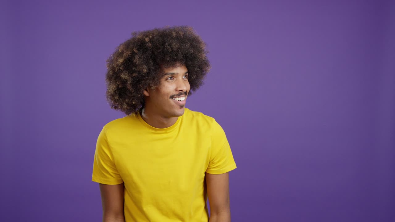 Homem com cabelo afro e bigode fazendo gestos com as mãos e expressões.