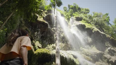 pan a través de una hermosa joven admirando la cascada de tumalog en filipinas