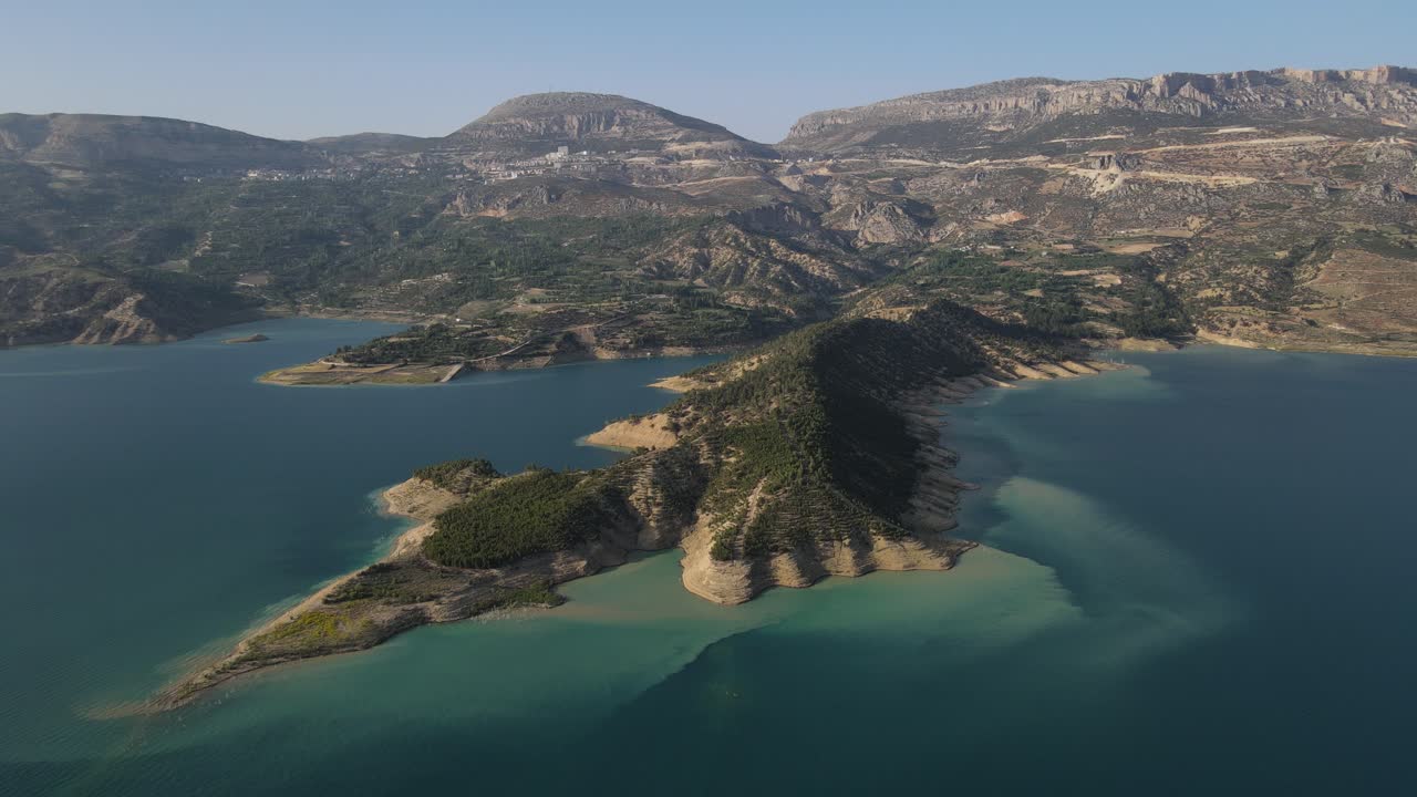 순수한 푸른 해변의 드론 뷰, 바다 한가운데의 섬 뷰, 구름 인 하늘과 절벽 해안