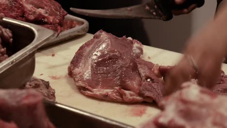 mujer corta tranquilamente la carne en la carnicería