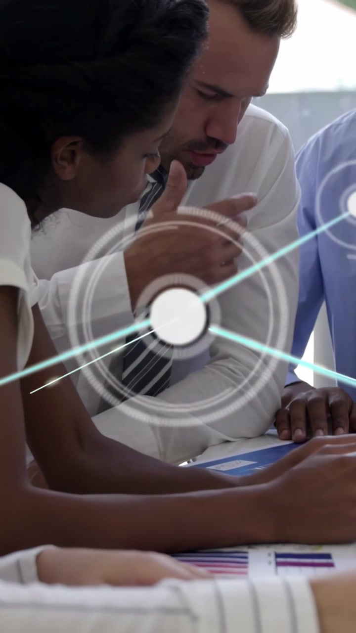 Vertical video: Hands opening pages, team leaning and noting charts for biz HUD nodes linking data
