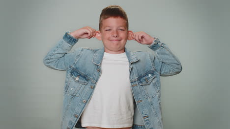 funny toddler boy making playful silly facial expressions, grimacing, fooling around showing tongue