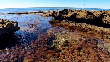 el agua se drena desde la orilla hasta el mar cuando baja la marea, rocky point, méxico