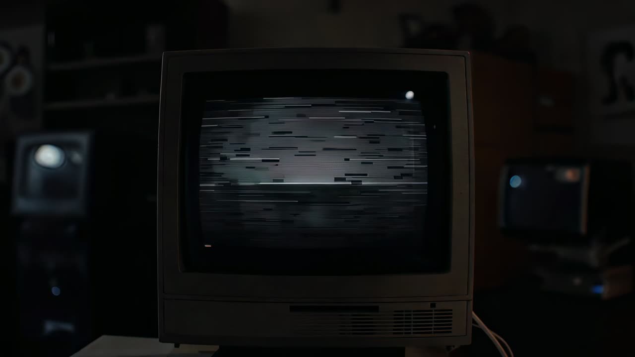 Powering vintage CRT monitor displaying static on table in living room, demonstrating signal glitch