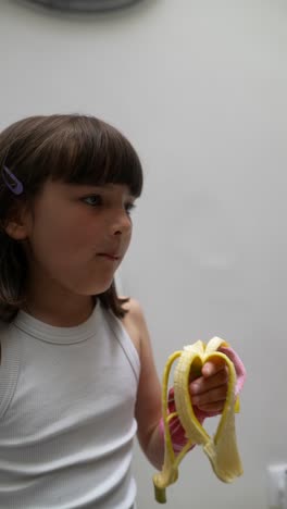 young girl eating a banana