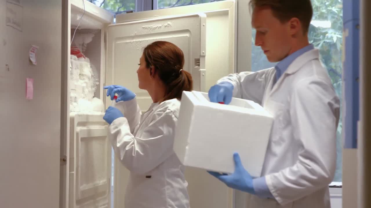 científicos que usan un refrigerador grande en el laboratorio