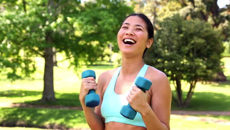 fit asian girl lifting dumbbells