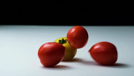 diferentes tipos de tomates cayendo en la superficie, vista de estudio